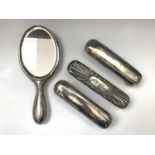 A silver-mounted mirror and three silver-mounted brushes