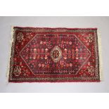 A red and blue ground Persian rug with diamond shaped central medallion 99cm x 60cmSome wear to