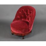 A Victorian tub back nursing chair upholstered in red buttoned material, raised on turned supports