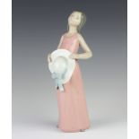 A Lladro figure of a girl holding a hat in front of her no.5088 26cm