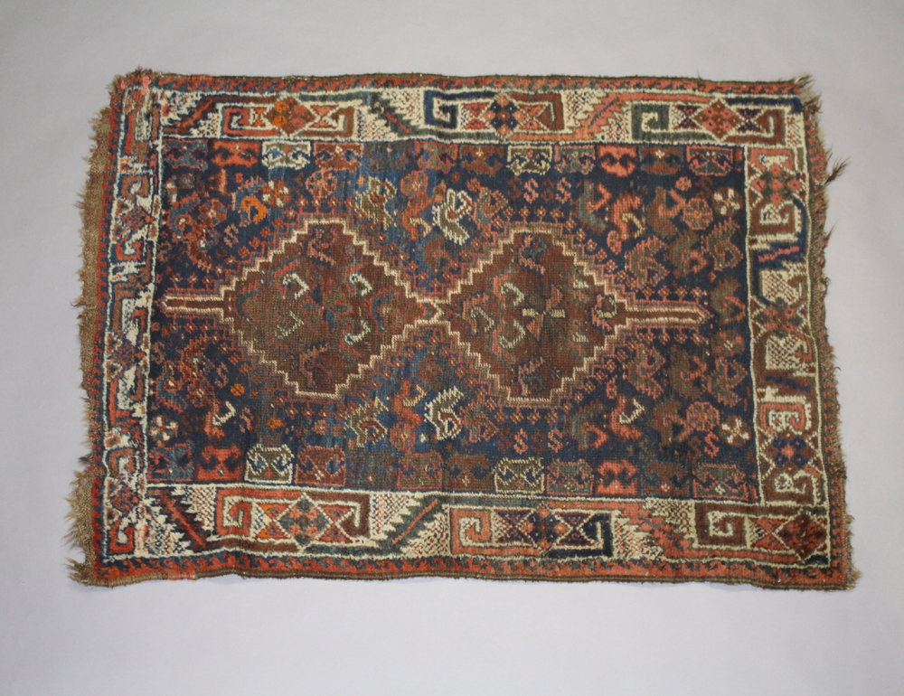 A blue and red ground Persian slip rug with 2 stylised medallions to the centre 123cm x 87cm In