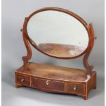 A Georgian mahogany oval plate dressing table mirror raised on a bow front base, fitted 3 drawers,