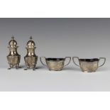 A pair of Edwardian silver boat shaped salts and liners and a pair of silver pepperettes, the