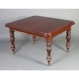 A Victorian mahogany extending dining table raised on turned and reeded supports and with 2 extra