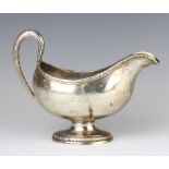 A George III silver sauce boat with egg and dart rim and simple S scroll handle with double