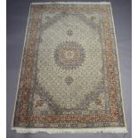 A green and white ground Persian carpet with central medallion within multi row border 295cm x 198cm