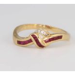 An 18ct yellow gold ruby and diamond crossover ring, size T 1/2, 3.9 grams