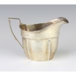 A George III silver cream jug with chased monogram London 1803, 179 grams