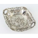 A Continental 800 standard shaped repousse dish decorated with cavorting cherubs surrounded by