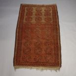 A red ground Afghan rug with 27 octagons to the centre 232cm x 135cm In wear
