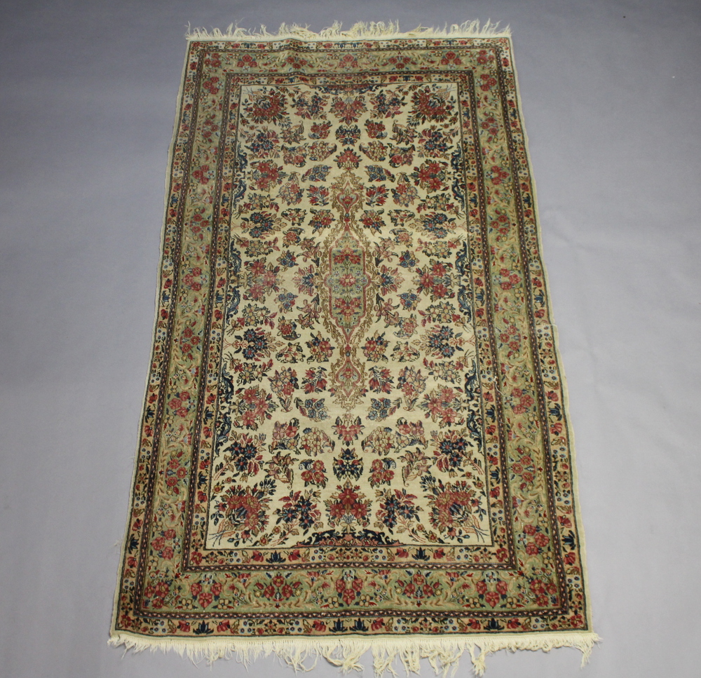 A white ground and floral patterned Persian carpet with central medallion within a multi row border,