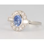 A platinum oval sapphire and diamond cluster ring, the centre stone approx. 1.2ct, the baguette