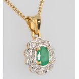 An 18ct yellow gold oval emerald and diamond cluster pendant, the centre oval cut stone approx. 1ct,