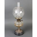 A Victorian faceted clear glass oil lamp raised on a pierced metal frame with etched glass shadeSome
