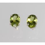 A pair of silver and peridot ear studs