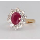 An 18ct yellow gold treated ruby and diamond cluster ring, the centre stone approx. 2.25ct, the
