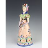 An English porcelain figure of a lady holding a flower and a book 33cm