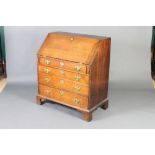 A George III oak bureau with fall front revealing a fitted interior above 4 long graduated drawers