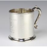 A Victorian silver mug of plain form with beaded rim and engraved inscription with S scroll handle