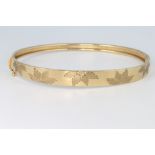 A 9ct yellow gold leaf engraved bangle 6.5 grams