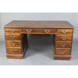 A mahogany kneehole desk with inset writing surface above 1 long and 8 short drawers with brass swan