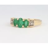 A 14ct yellow gold emerald and diamond ring, size N, 2.8 grams