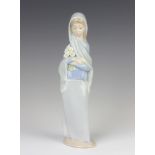 A Lladro figure of a lady holding lilies 4650 23cm