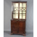 A 19th Century mahogany display cabinet on cabinet, the upper section with moulded cornice, fitted