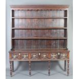 A Georgian oak dresser, the raised back fitted 3 shelves and with moulded cornice, the base fitted 3