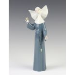 A Lladro figure of a nun holding a hand bell, 27cm