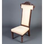 A Victorian carved and pierced oak prie-dieu chair upholstered in yellow floral material raised on