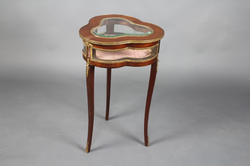 A French mahogany and gilt metal mounted bijouterie table of clover form with hinged lid, raised