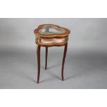 A French mahogany and gilt metal mounted bijouterie table of clover form with hinged lid, raised