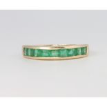 A 9ct yellow gold Princess cut emerald half eternity ring size O 1/2, 2.6 grams