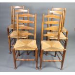 A set of 6 18th Century style elm ladderback dining chairs with woven rush seats raised on club