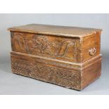 A 18th Century Continental carved hardwood coffer with hinged lid and iron drop handles to the