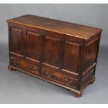 An 18th Century oak mule chest of panelled construction with hinged lid, the base fitted 2 long