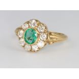 An 18ct yellow gold oval emerald and diamond cluster ring, the centre stone approx. 0.70ct