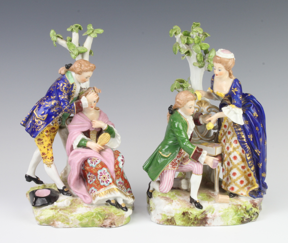 A pair of 19th Century Derby style figure groups of a lady and gentleman seated beneath a tree