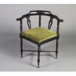 A Victorian ebonised corner chair with turned and splat back and upholstered drop in seat, raised on