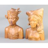 A pair of Bali carved hardwood head and shoulders portraits busts of a lady and gentleman, bases