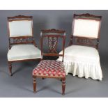 A pair of Edwardian carved and pierced walnut nursing chairs with upholstered seats and backs raised