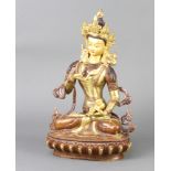 An Eastern gilt bronze and cold painted figure of a seated deity 30cm h x 18cm w x 13cm d