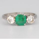 A platinum emerald and diamond ring, the centre square cut emerald approx. 1ct flanked by