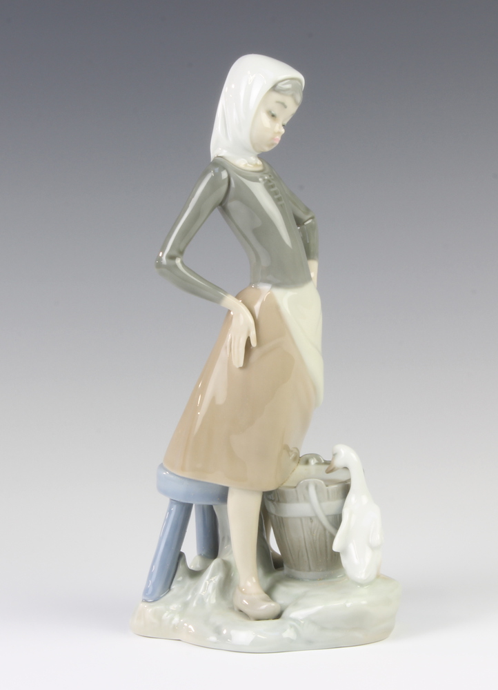 A Lladro figure of a girl with a bucket of water and a goose at her feet, 23 cm