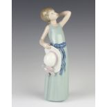 A Lladro figure of a girl holding her hat 5010 25cm
