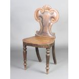 A Georgian oak hall chair with shield shape back and solid seat, raised on turned supports There are