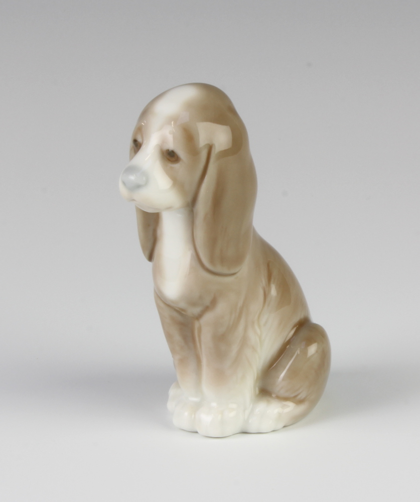 A Lladro figure of a seated puppy hound 8cm