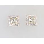 A pair of 18ct white gold diamond ear studs, the centre set with a princess cut diamond, each
