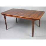 A H Mcintosh & Company Ltd, a 1970's rosewood extending dining table raised on turned supports